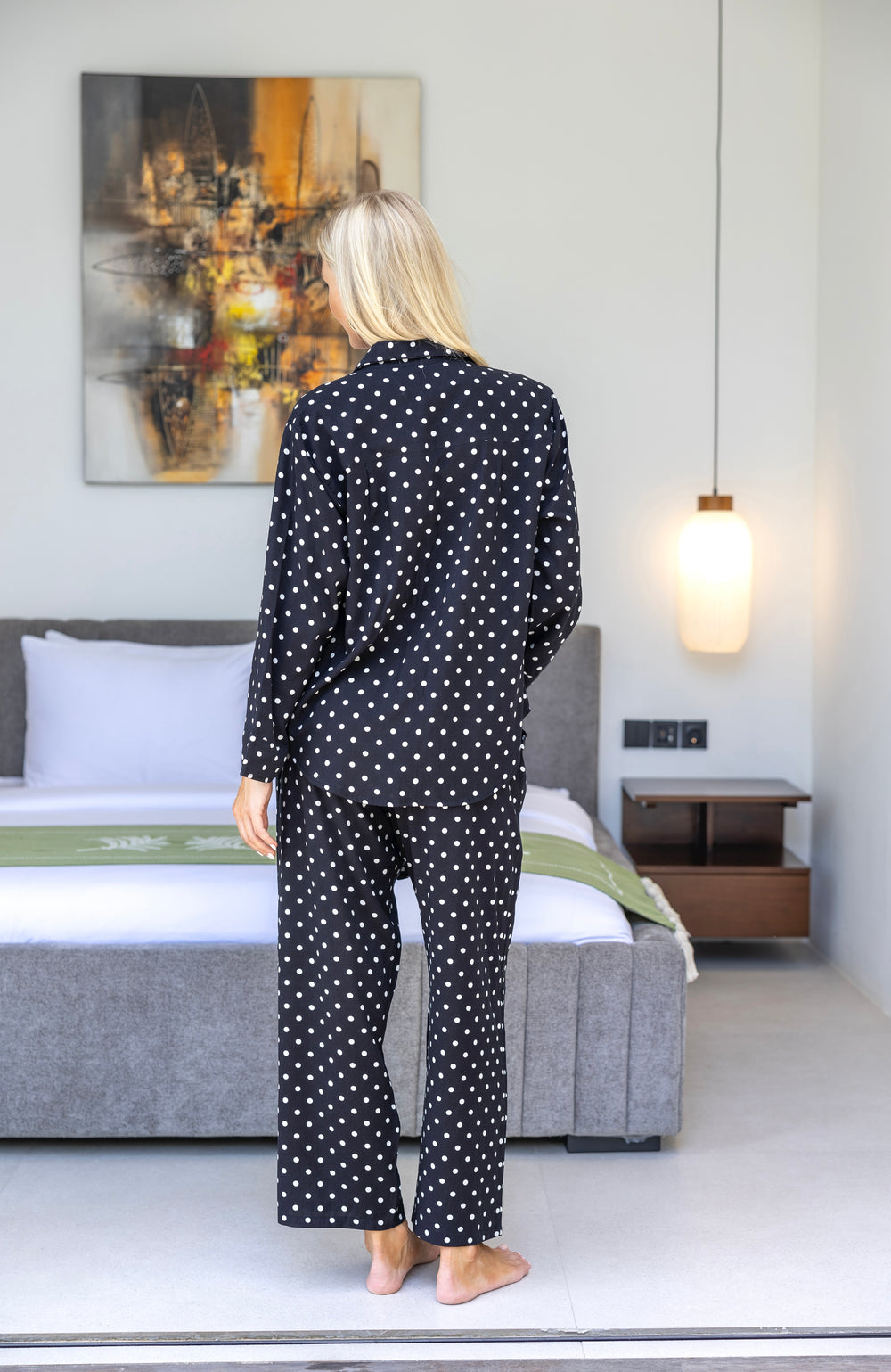 women wearing black and white polka dot long pyjama set, back view